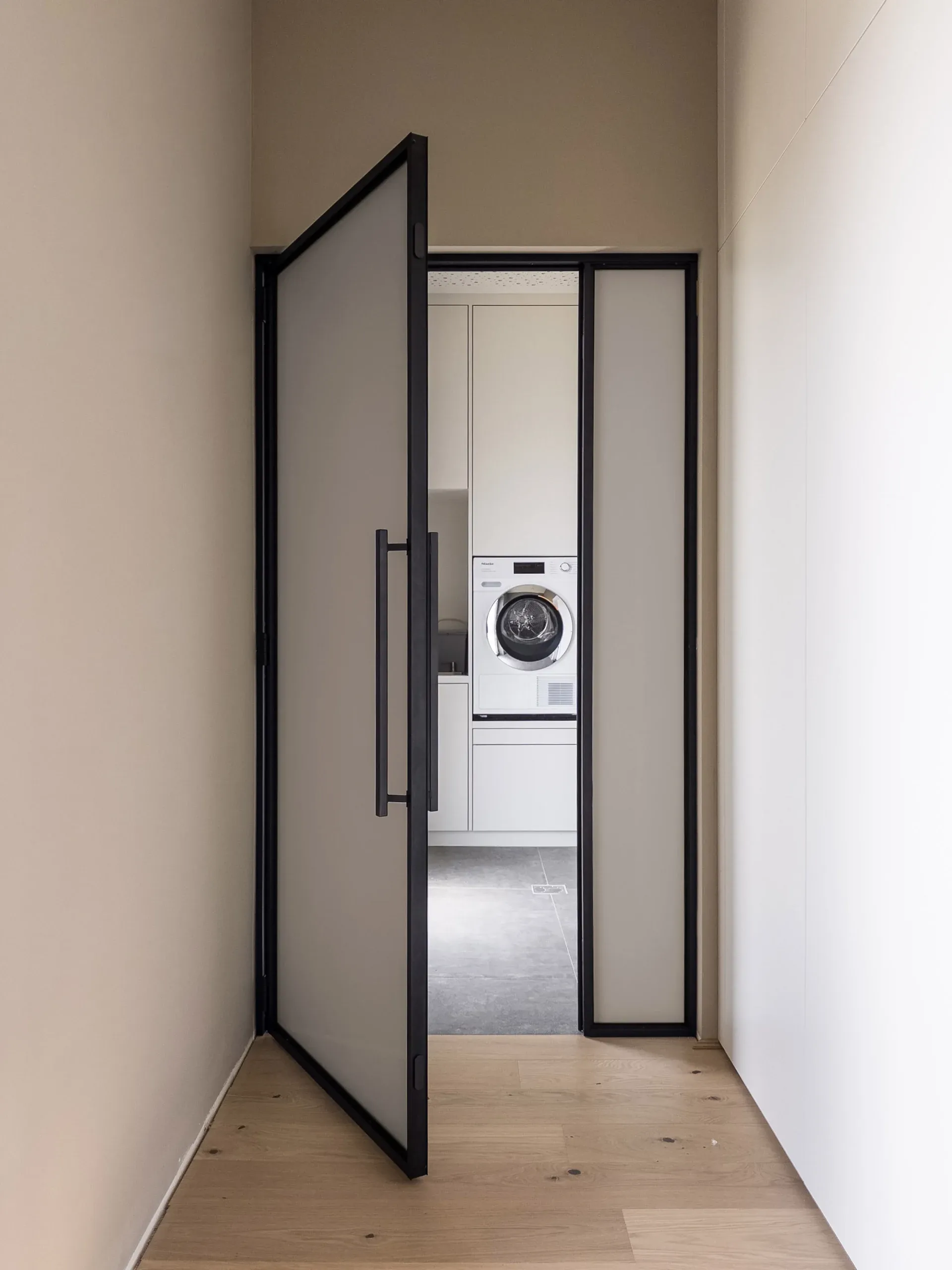 Dieselbe schwarze Drehtür mit bronzefarbenem Mattglas — blickhemmend in warmer Tönung.