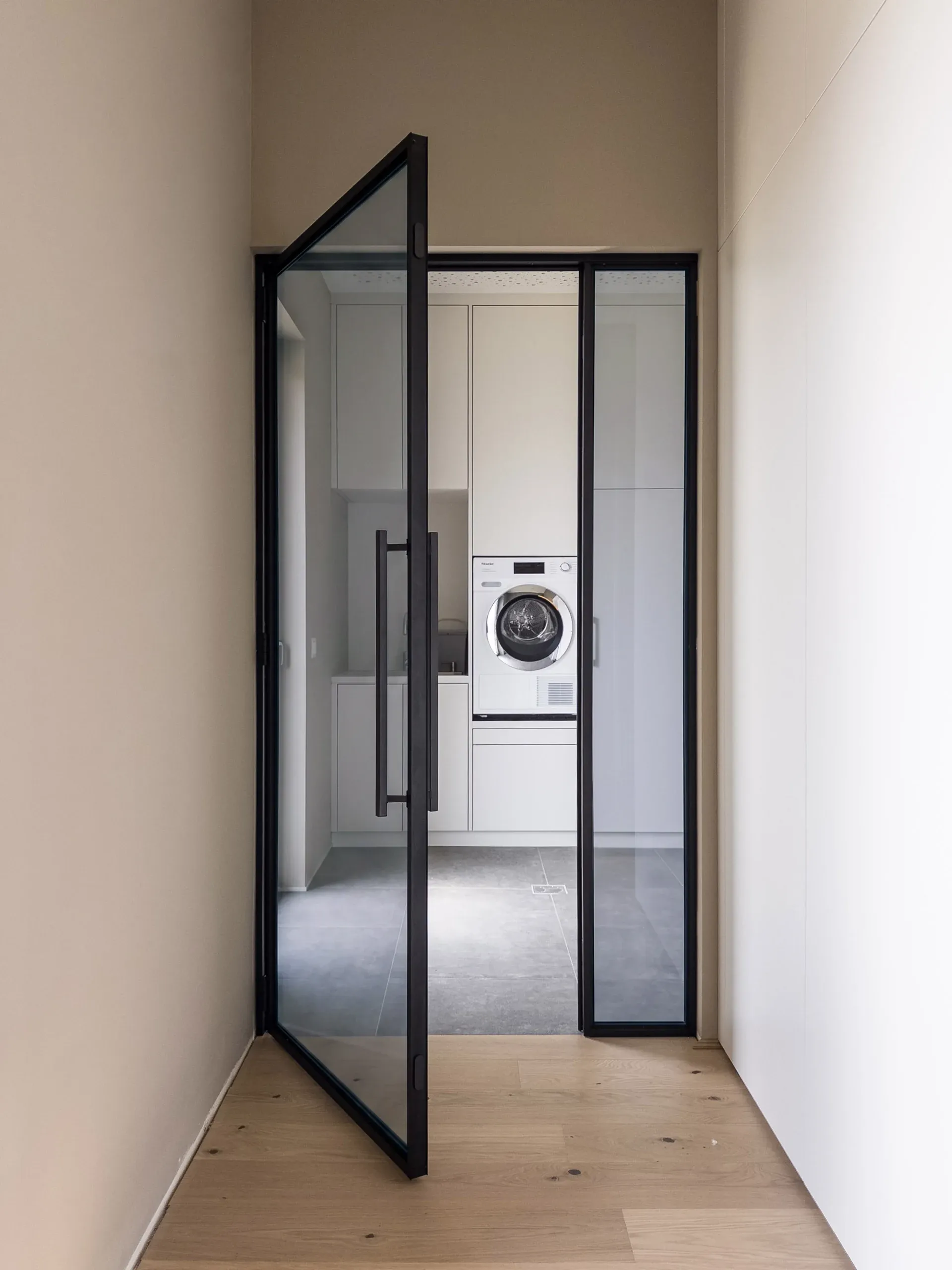 Dieselbe schwarze Drehtür mit Grauglas — transparent mit kühler, grauer Tönung.
