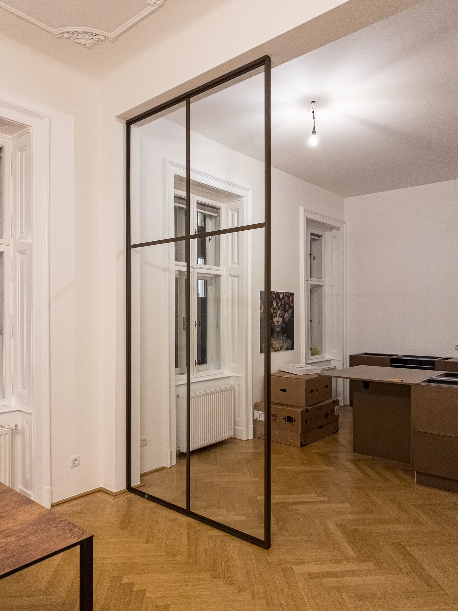 Fertiger fester Raumteiler in Bronze mit Klarglas und flachen Sprossen in einer Altbauwohnung in Wien