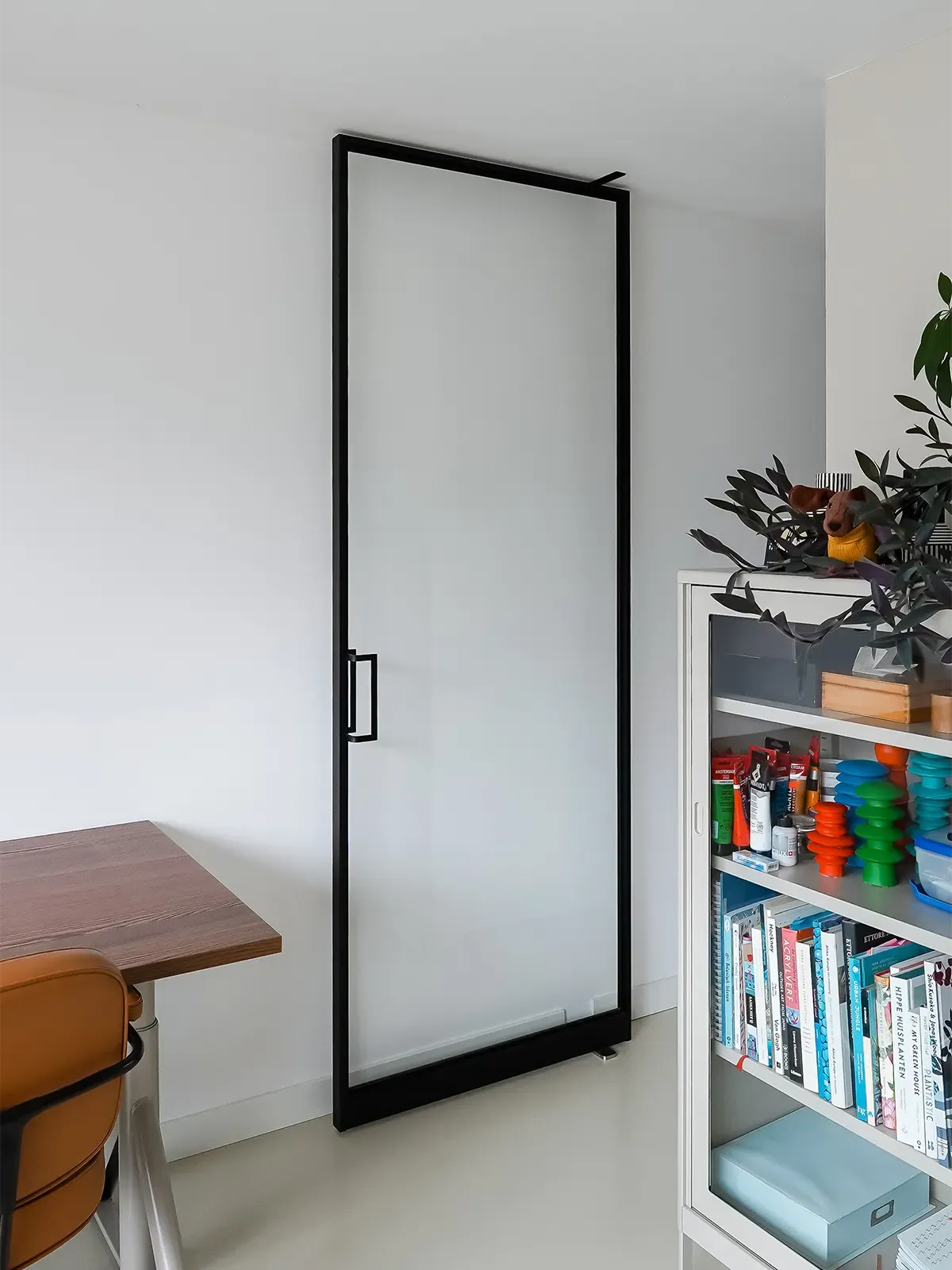 Pivot-Tür ohne Sprossen in einem hellen Wohnraum.