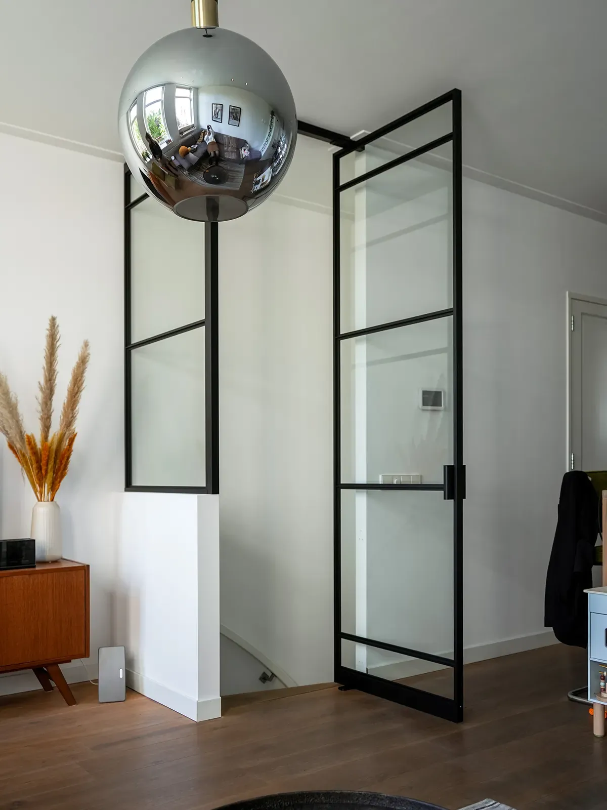 Loft-Raumteiler mit Eckverbindung und Pivottür in einer größeren Glaslösung.