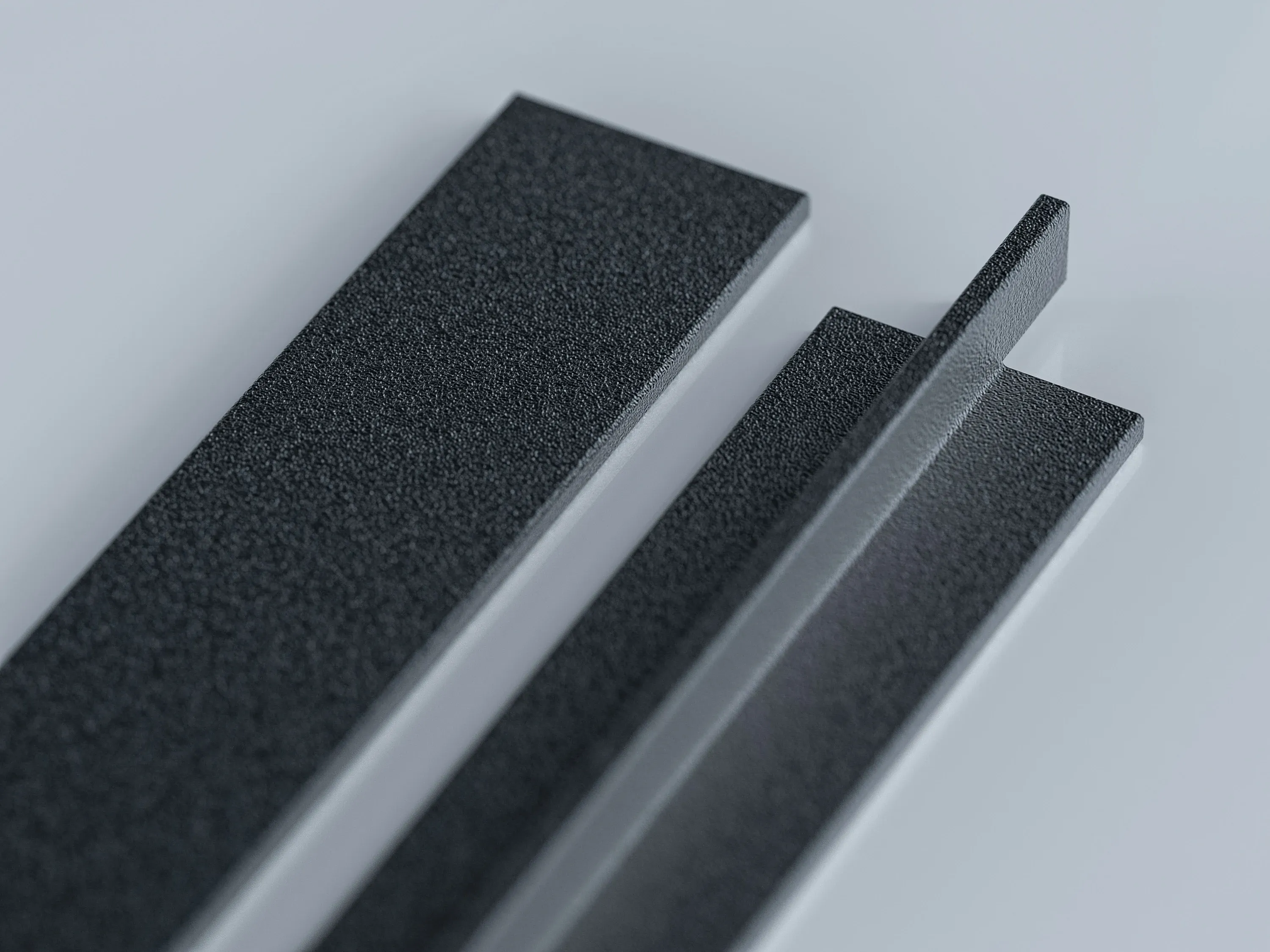 Zwei schwarze Aluminium-Sprossenprofile nebeneinander: links das flache Profil, rechts das T-Profil mit hochstehendem Steg.