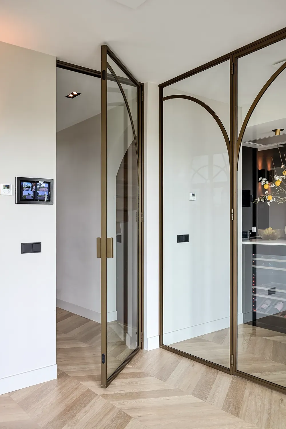 Moderne Aluminium-Lofttür in Bronze mit gebogenen Sprossen und Magnetverschluss.