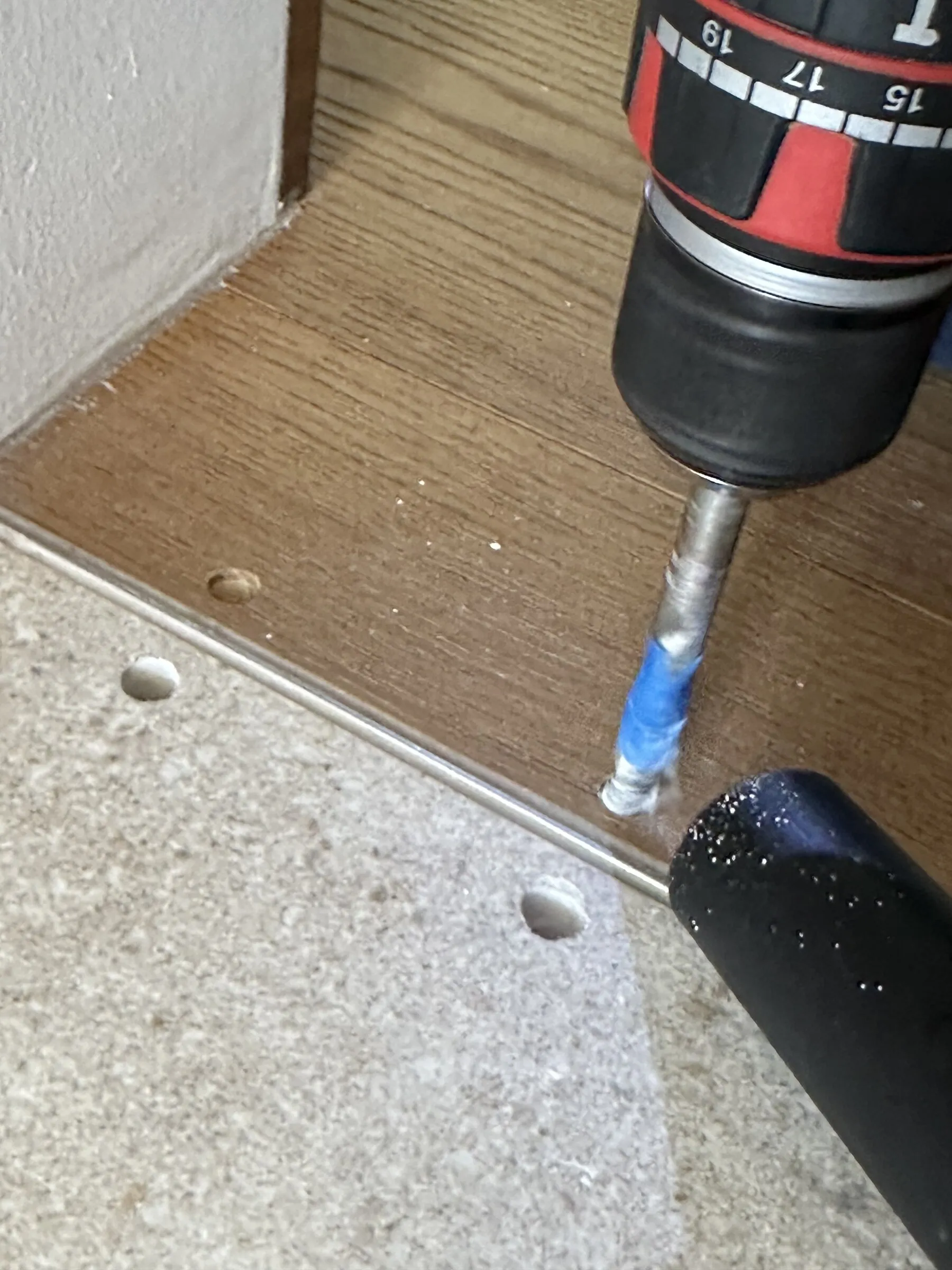 Bohrung auf der Parkettseite neben dem Fliesenübergang mit Absaugung.